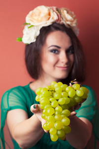 年轻女子戴花环及持绿葡萄