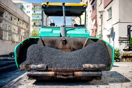 工业铺设公路建设过程中的新鲜沥青和在卵砾石层的沥青路面的摊铺机