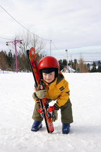 戴红色头盔电梯滑雪的男孩