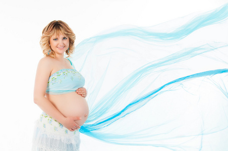 未来的怀孕母亲与飞行蓝色织物的白色背景上