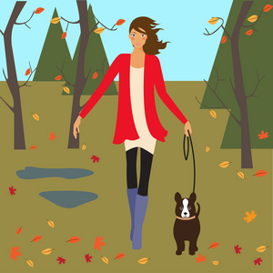 女孩和狗走在秋天的公园