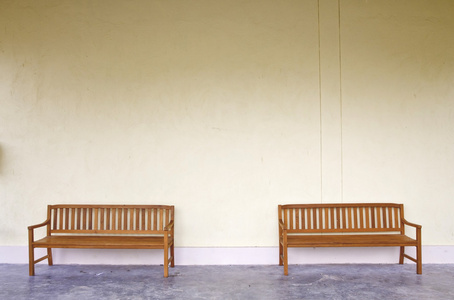空白的墙上的两个木长椅