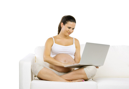 孕妇在膝上型电脑上打字
