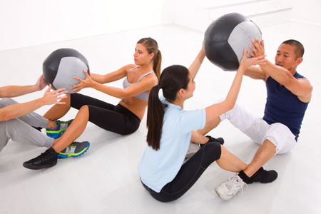 不同群体的人们在健身房用普拉提锻炼