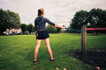 带阻力时在公园里锻炼的女人