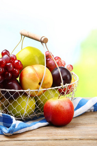 琳琅满目的多汁的水果，在柳条篮子在桌子上，在明亮的背景上