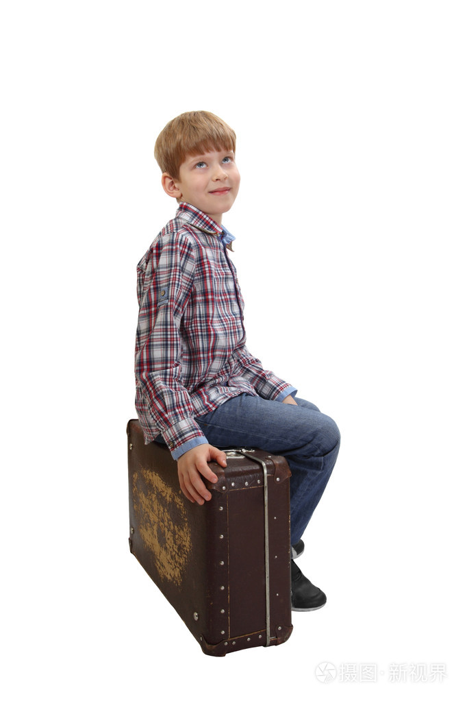 男孩坐在老式手提箱