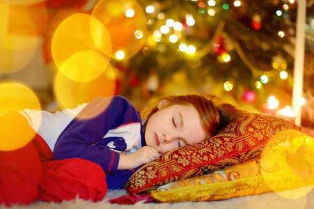女孩睡在圣诞树下