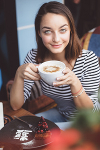 在城市的咖啡厅里喝咖啡的年轻女子