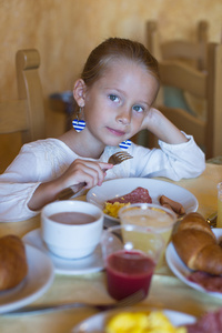 可爱的小女孩，在度假村的餐厅吃早餐