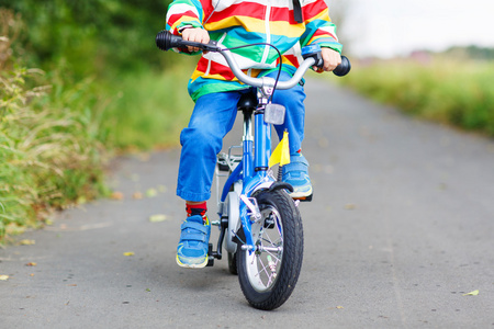在五颜六色的雨衣，他第一次骑车的孩子