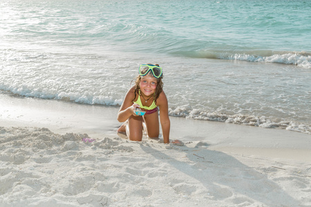 在日落的时候在白色背景下海洋热带沙滩上玩的开心快乐的小孩