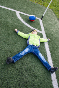躺在草地上的小男孩足球球