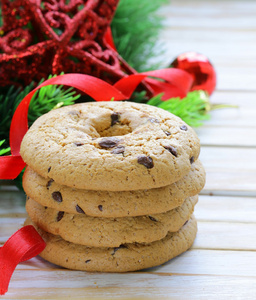 与圣诞树枝和装饰的木制背景上的巧克力饼干