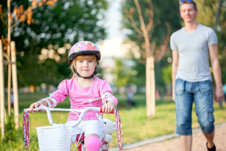 父亲教他女儿骑自行车