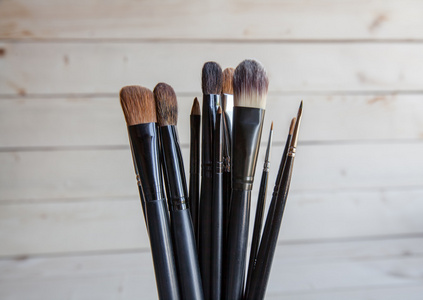 化妆在一个木制的背景上的黑色笔刷