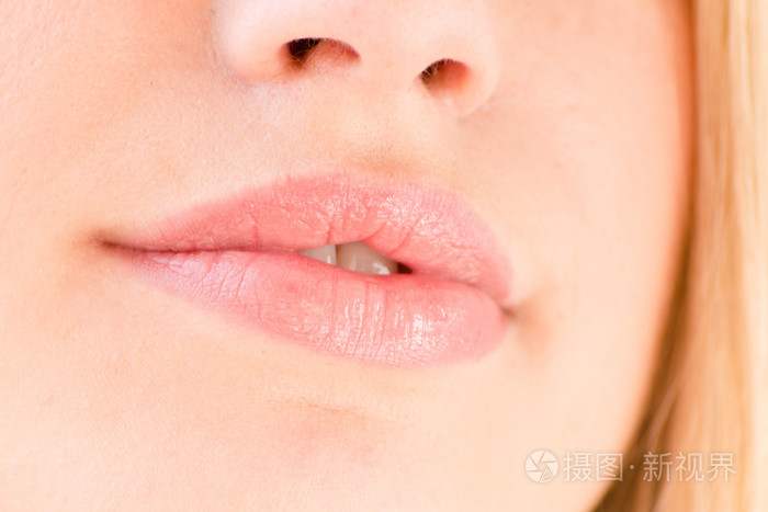 美丽的金发女孩丰满圆润的嘴唇上白色背景特写的形象