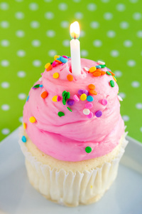 粉红色糖霜和蜡烛的香草蛋糕