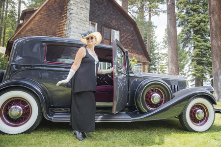 有魅力的女人，在二十年代装备附近古董汽车