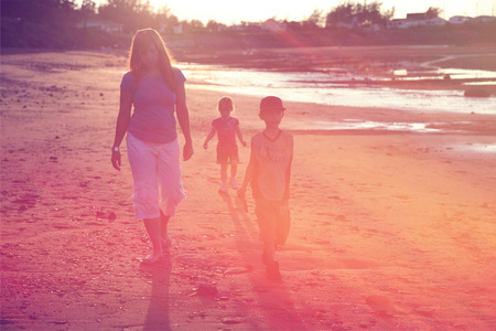 妈妈和孩子们在海滩上行走