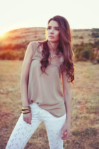 schne brunette Dame im Feld bei Sonnenuntergang