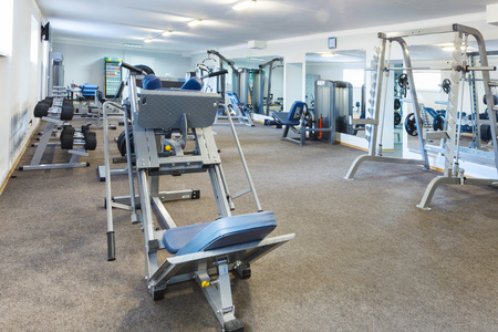 健身房室内坐在长凳上用毛巾擦汗的非裔美国运动员.