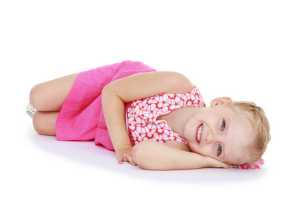可爱的小女孩微笑着躺在地板上