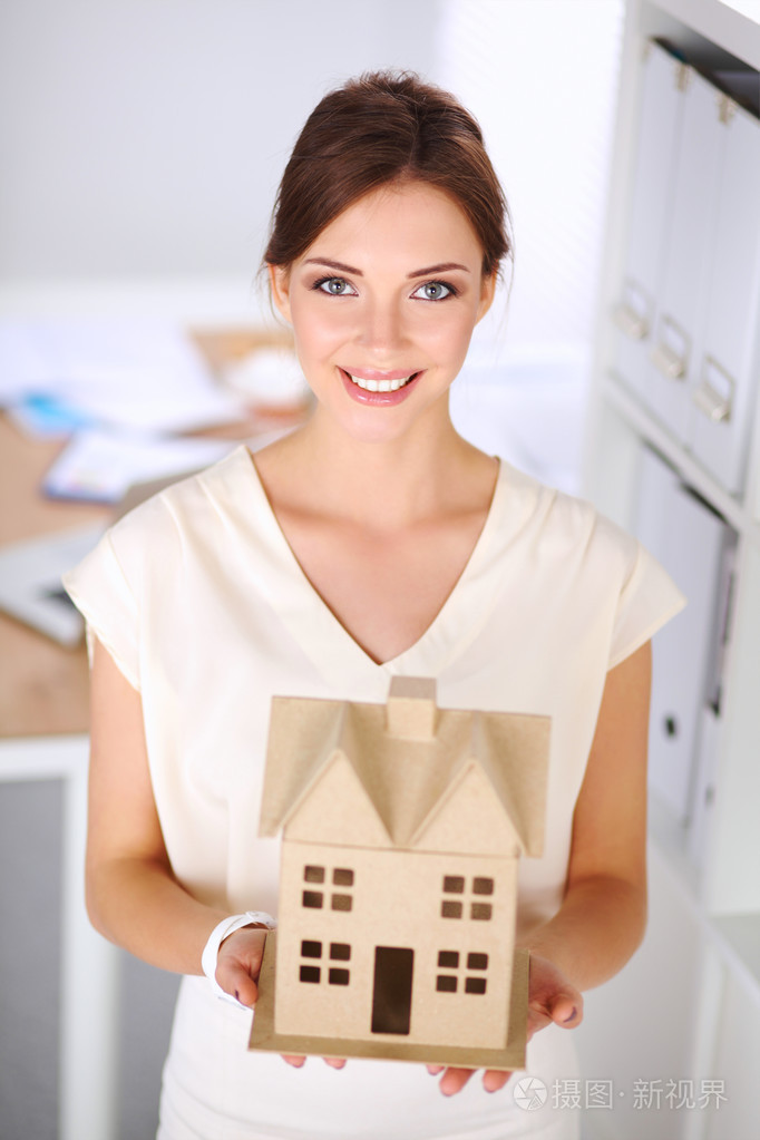 女建筑师持有一所小房子站在我的画像