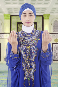 房子朝向在清真寺做礼拜的穆斯林女人照片