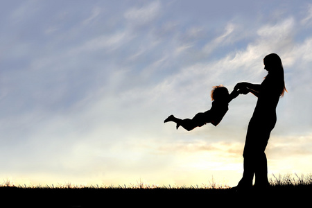 在日落时玩外面的孩子的母亲的剪影照片