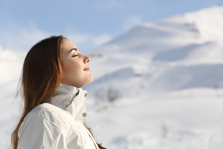 资源管理器中女人呼吸新鲜的空气在冬天在一座雪山