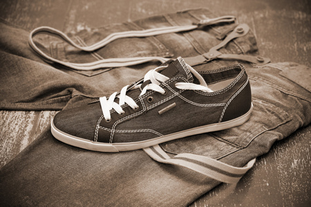 时髦的运动鞋和牛仔裤，在棕褐色色调的照片
