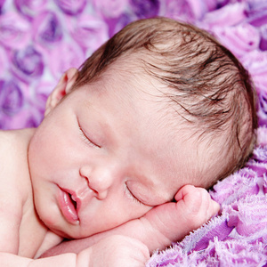 新生女婴上紫色毛毯睡觉