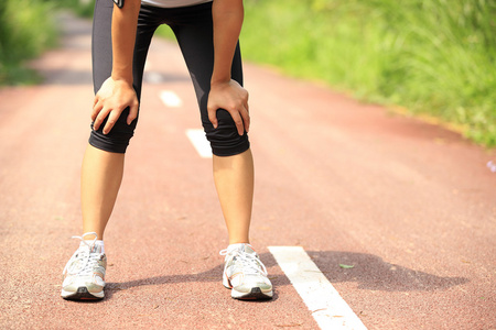 累了的女跑步运动员休息后运行硬在乡村的道路照片