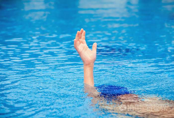 一只手的一个溺水的人,伸出一个游泳池里的水.帮助概念