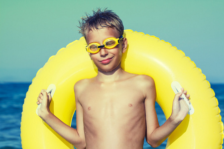 游泳搞笑自拟护目镜站在黄色的浮面带笑容的海滩上