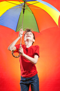 穿红 t 恤，拿着五彩的伞跳美丽有趣的男孩男孩