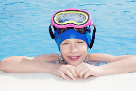 美丽快乐的孩子戴着游泳面罩在游泳池微笑