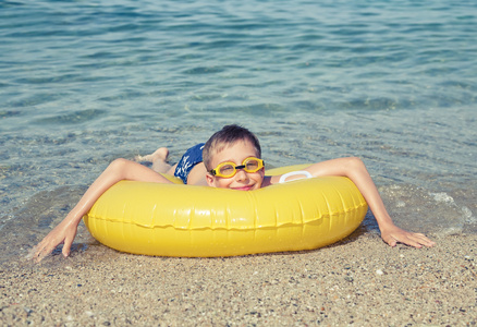 护目镜躺在黄色的漂浮在海洋海岸微笑享受暑假的有趣小自拟