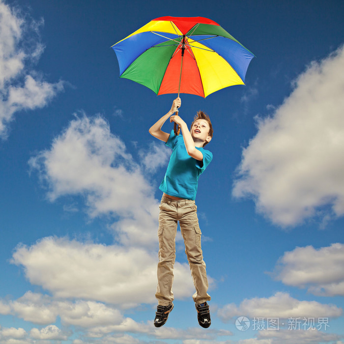 可爱搞笑小孩子的 t 恤,在五颜六色的伞的天空中飞翔