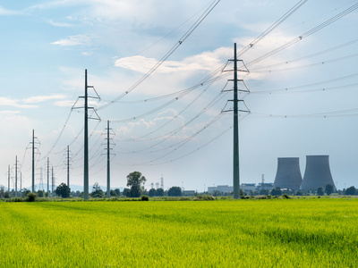 高低压电力线路.在背景中的前景绿色字段照片
