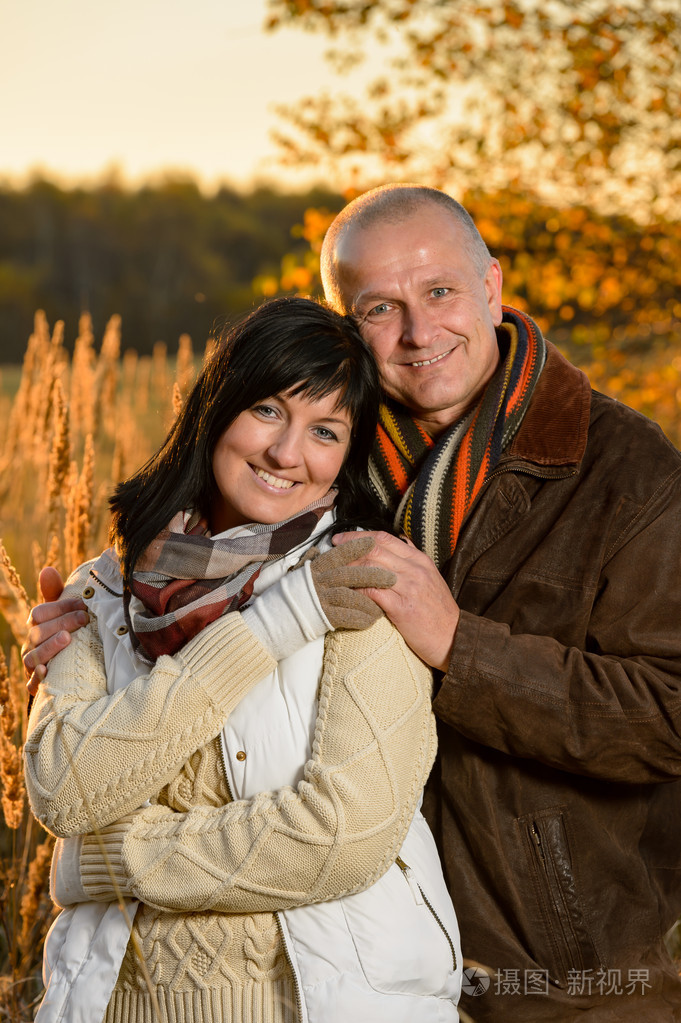 浪漫的情侣,在秋天的日落公园深情相拥