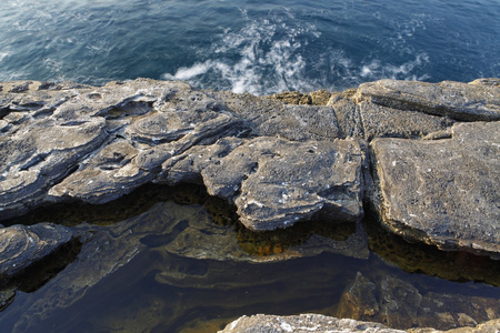 在希腊的爱琴海岸，萨索斯岛岛屿波和岩石长时间曝光摄影