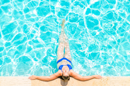 女人放松在游泳池边上