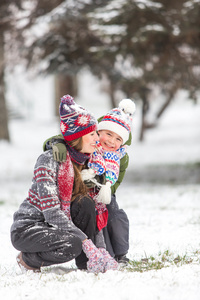 幸福的母亲和儿子在冬季公园玩乐