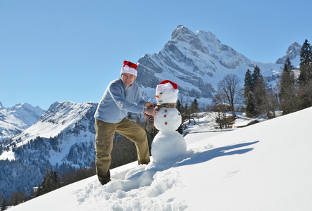男人在圣诞老人的帽子和雪人