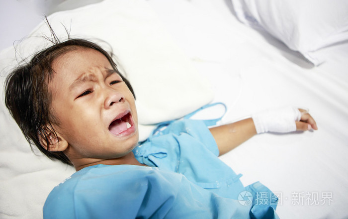 生病的小女孩在医院的病床上哭