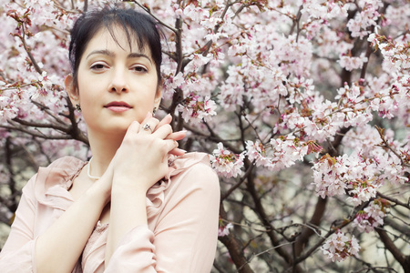 黑发女人在春天花朵的花园