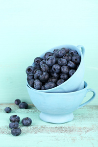 美味成熟的蓝莓在木桌上的杯子