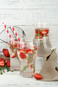 美味清凉饮料的草莓和百里香，木制的背景上